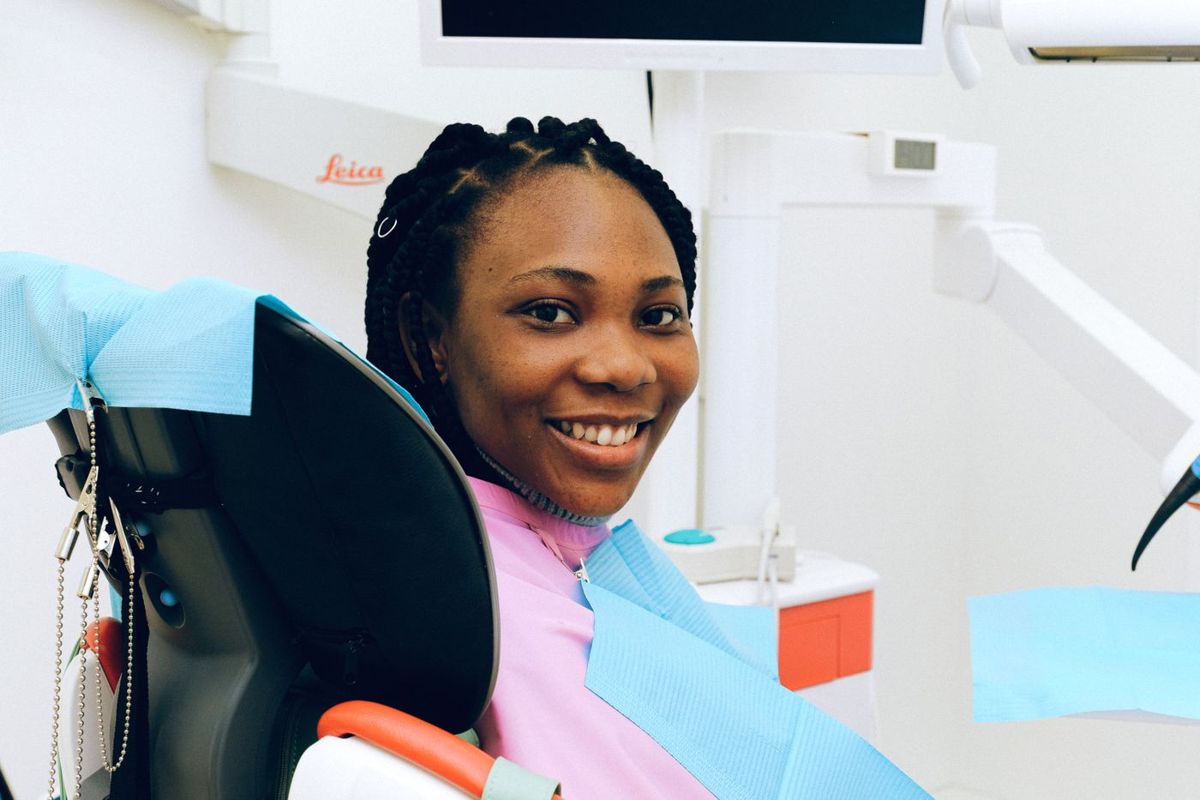 Smiling patient in a dental chair (illustrative stock photo)